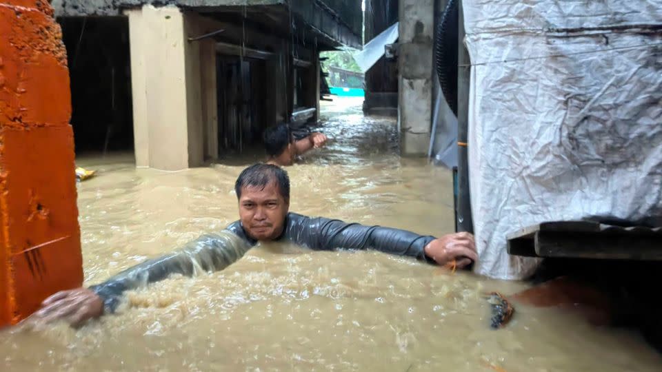 A man negotiates neck-deep floodwaters in Laoag city, Ilocos Norte province, northern Philippines. - Bernie Sipin Dela Cruz/AP