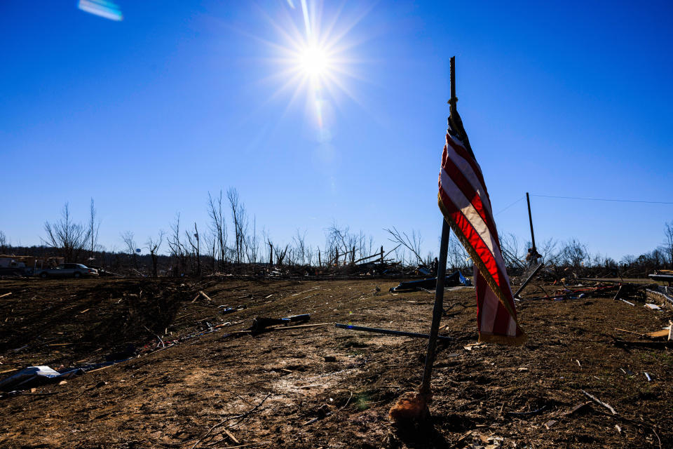 An American flag stands alone in an area swept by a tornado.