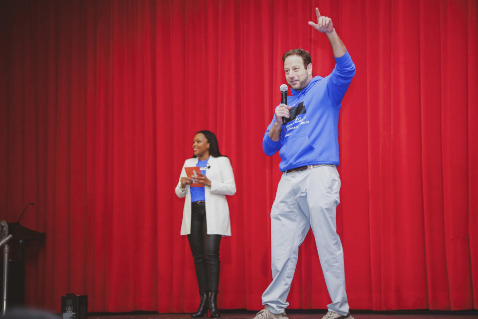 In this image provided by Hope Chicago, Pete Kadens, Hope Chicago co-founder, shares the stage with Dr. Janice Jackson, CEO of Hope Chicago, where they announced on Feb. 25, 2022, that the entire student body, 503 students total, at Farragut Career Academy High School in Chicago, were receiving full, debt-free college scholarships to partner colleges and universities. (Hope Chicago via AP)