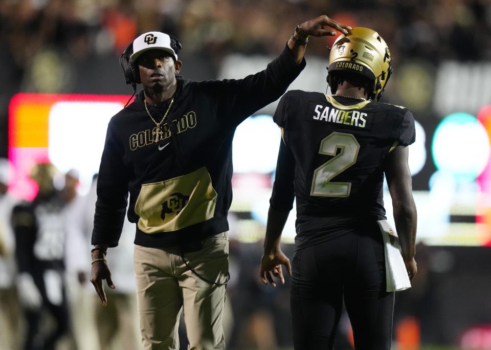 Colorado quarterback Shedeur Sanders (2) and head coach Deion Sanders react following a two-point conversion in the fourth quarter.