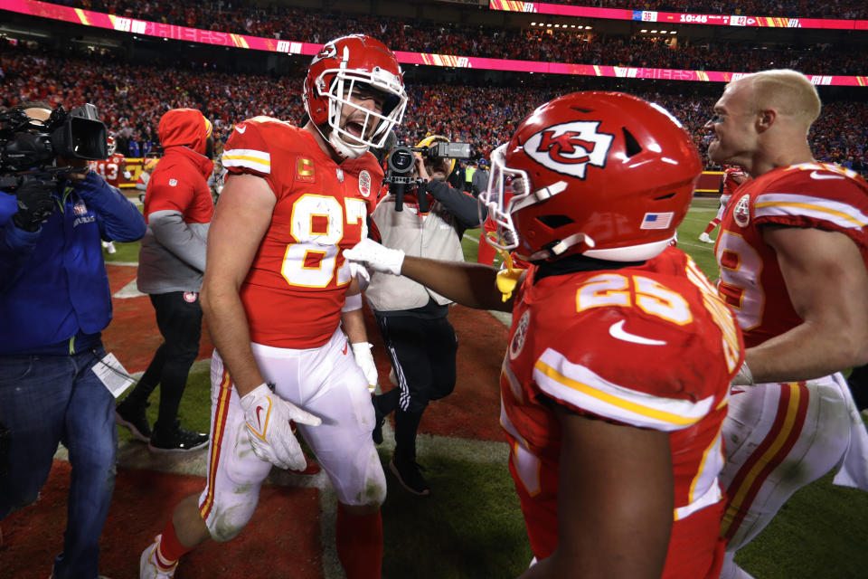 Kansas City Chiefs tight end Travis Kelce (87) celebrates with teammate Clyde Edwards-Helaire (25) after catching an 8-yard touchdown pass during overtime in an NFL divisional round playoff football game against the Buffalo Bills, Sunday, Jan. 23, 2022, in Kansas City, Mo. The Chiefs won 42-36. (AP Photo/Colin E. Braley)