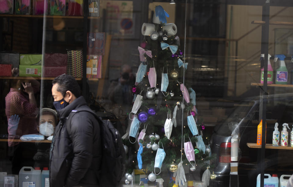 A christmas tree decorated with face masks and toilet rolls is displayed in a store in the street in Madrid, Spain, Thursday, Dec. 17, 2020. Some of Spain's regions are tightening health restrictions for the Christmas holidays with new COVID-19 cases already on the rise again. (AP Photo/Paul White)