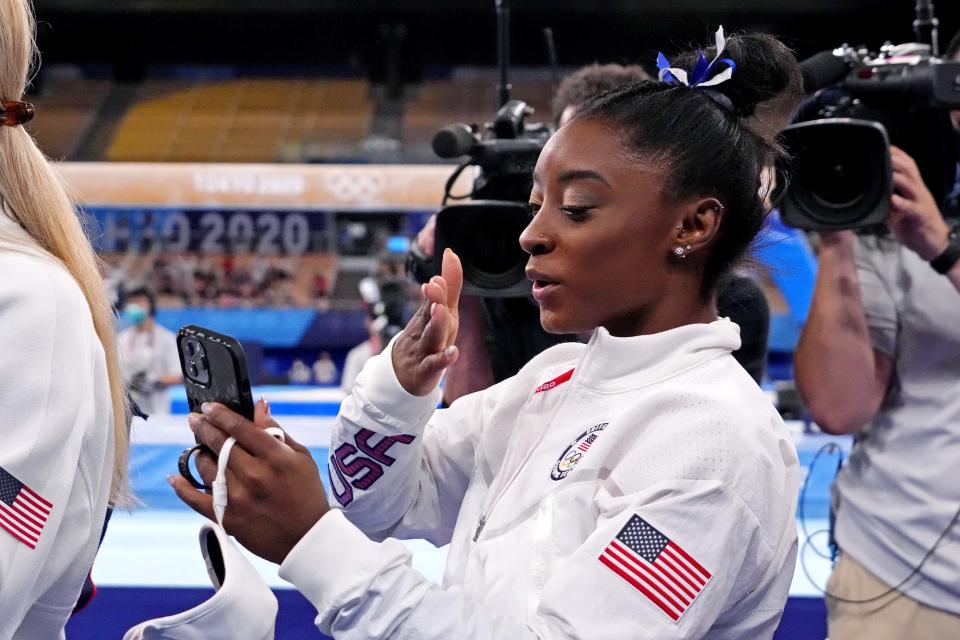 Aug 3, 2021; Tokyo, Japan; Simone Biles (USA) talks on a phone after competing on the balance beam during the Tokyo 2020 Olympic Summer Games at Ariake Gymnastics Centre. Mandatory Credit: Robert Deutsch-USA TODAY Sports