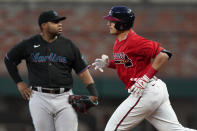 Atlanta Braves' Austin Riley, right, runs past Miami Marlins first baseman Jesus Aguilar after hitting a home run in the fifth inning of a baseball game Friday, May 27, 2022, in Atlanta, Ga. (AP Photo/John Bazemore)