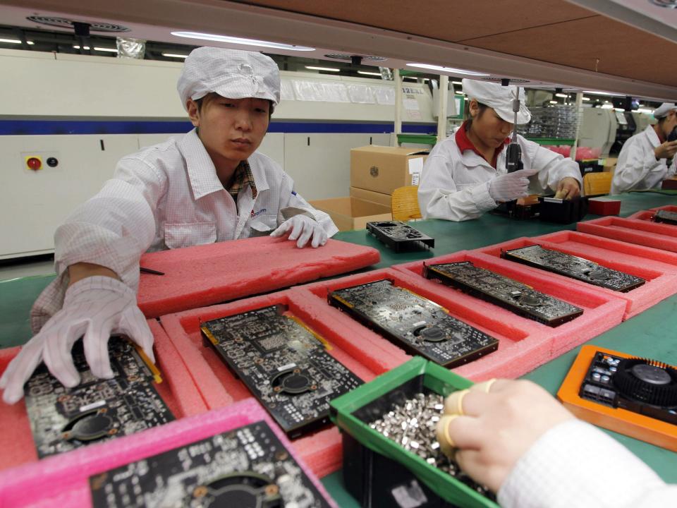 In this May 26, 2010 file photo, staff members work on the production line at the Foxconn complex in the southern Chinese city of Shenzhen, Southern city in China.