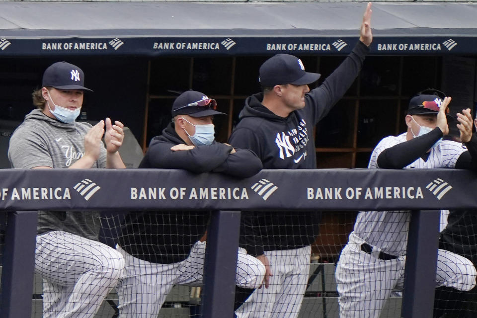 New York Yankees outfielder Jay Bruce, third from left, waves from the dugout as injured first baseman Luke Voit, left, applauds, while outfielder Brett Gardner rests on the railing as the Yankees announced Bruce's retirement from baseball during the seventh inning of the Yankees loss to the Tampa Bay Rays in a baseball game, Sunday, April 18, 2021, at Yankee Stadium in New York. (AP Photo/Kathy Willens)