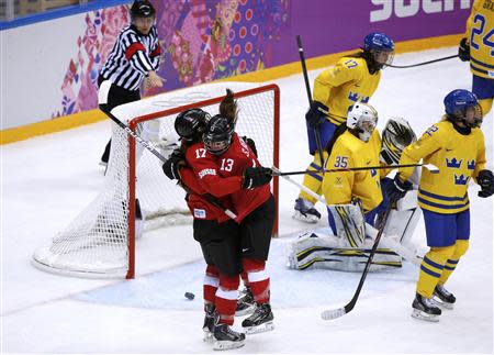 Switzerland's Jessica Lutz celebrates her goal against Sweden's goalie Valentina Wallner (35) with teammate Sara Benz (13) as Sweden's Linnea Backman (17) and Emma Eliasson (22) skate away during the third period of their women's ice hockey bronze medal game at the Sochi 2014 Winter Olympic Games February 20, 2014. REUTERS/Grigory Dukor