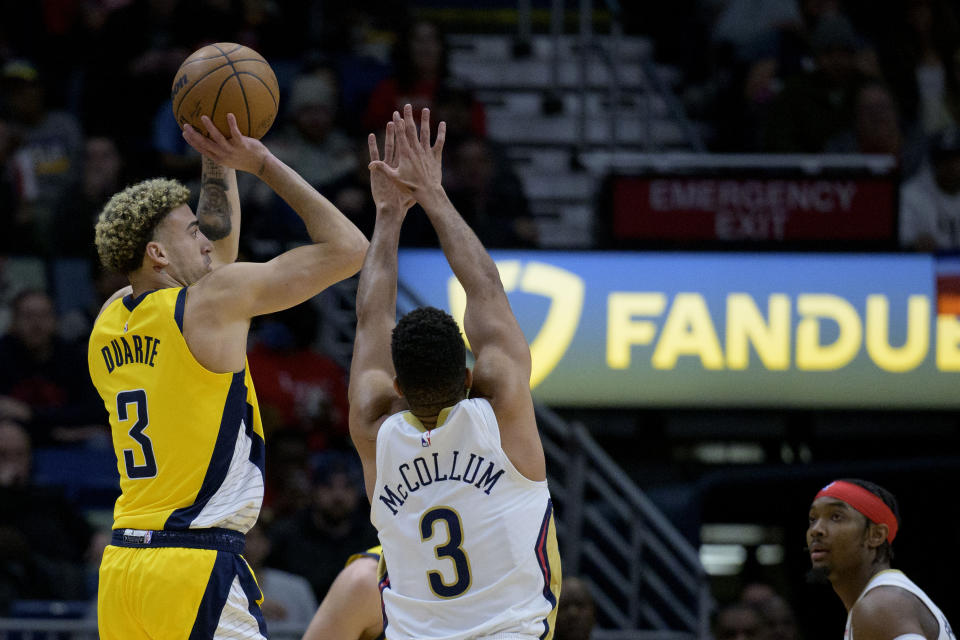 Indiana Pacers guard Chris Duarte, left, shoots against New Orleans Pelicans guard CJ McCollum, second from left, in the first half of an NBA basketball game in New Orleans, Monday, Dec. 26, 2022. (AP Photo/Matthew Hinton)