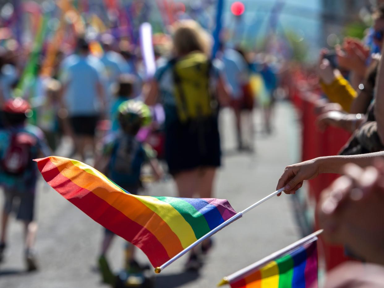 A festival-goer waves a rainbow pride flag at the 2019 Utah Pride Parade.