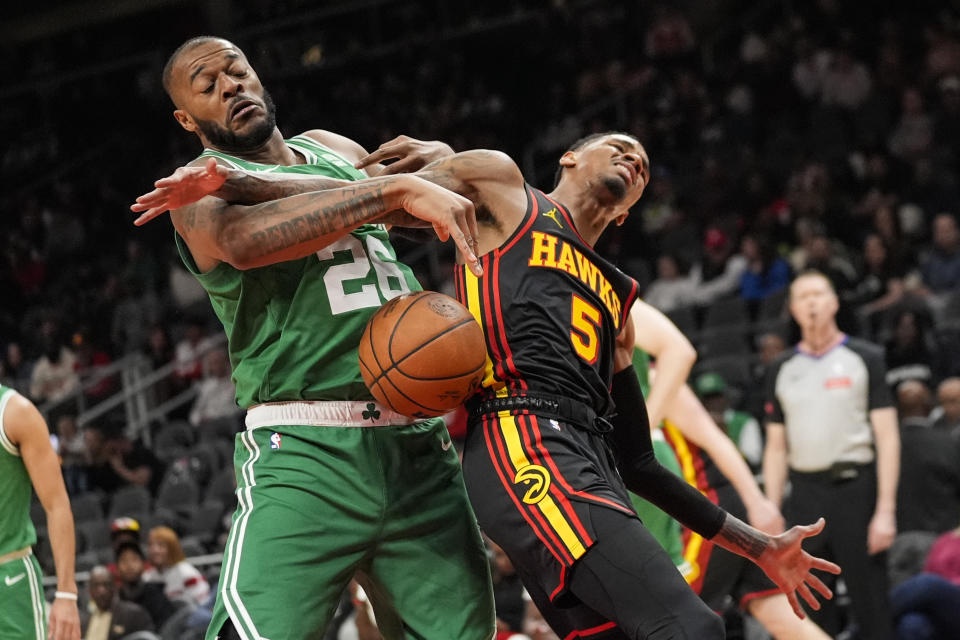 Boston Celtics forward Xavier Tillman (26) and Atlanta Hawks guard Dejounte Murray (5) battle during the first half of an NBA basketball game Thursday, March 28, 2024, in Atlanta. (AP Photo/John Bazemore)