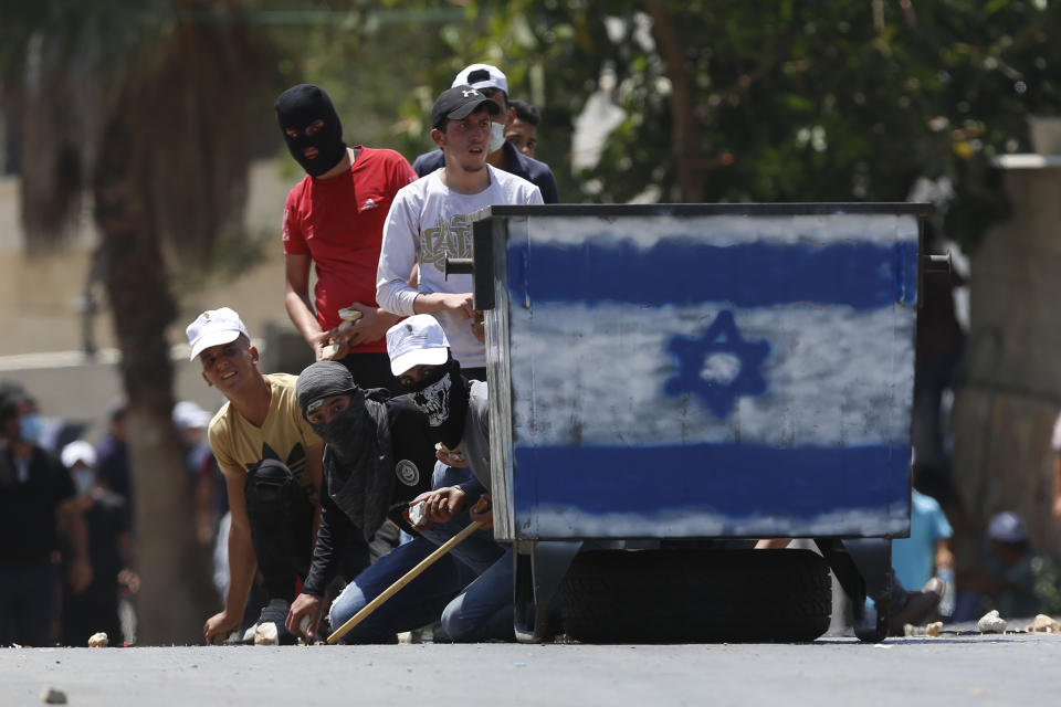 Palestinian demonstrators hurl stones at Israeli troops during a protest Israel's plan to annex parts Israel's plan to annex parts of the West Bank and Trump's mideast initiative, in the West Bank village of Kufr Qaddumm near Nablus, Friday, July 3, 2020.(AP Photo/Majdi Mohammed)