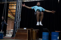 Student Lotke Janssens, left, practices on the aerial straps as Marius Broucke, right, practices his floor acrobatics at the Ell Circo D'ell Fuego circus school in Antwerp, Belgium, Friday, Sept. 18, 2020. The non-traditional school is a collective where young people who are interested in circus performance can further grow and train before showing their skills to an audience. (AP Photo/Virginia Mayo)