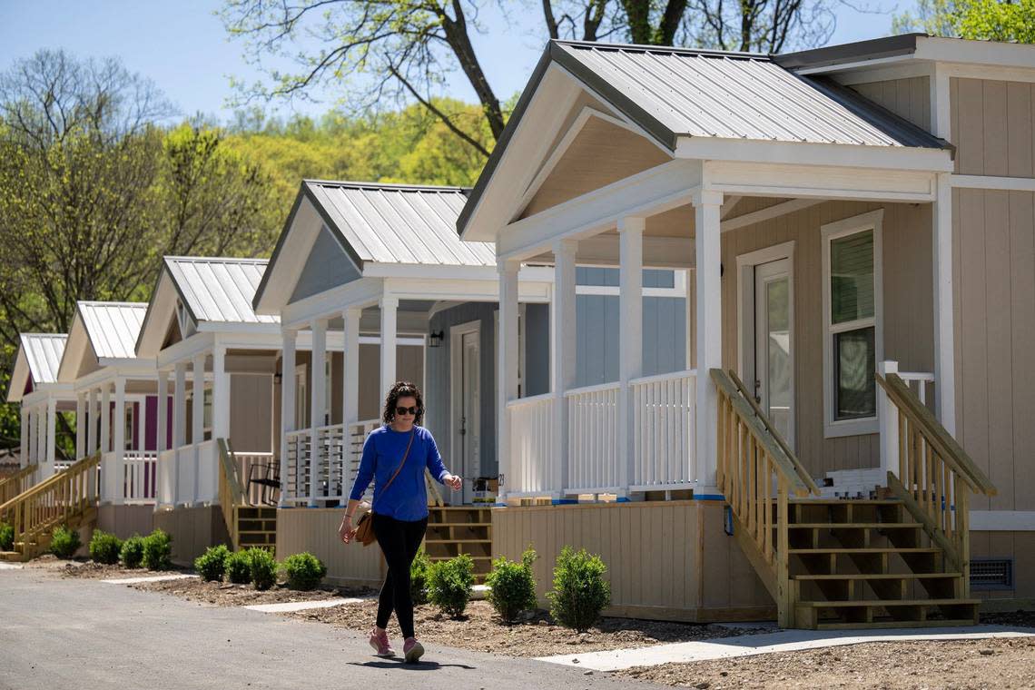 Volunteer Jo Overholt of Olathe, walks past some of the 21 tiny homes at Eden Village of Kansas City, a community of that will provide stable housing for the chronically homeless in Kansas City, Kansas.