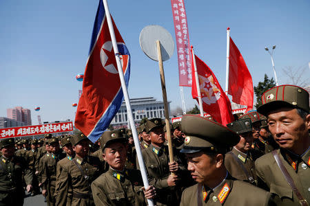 North Korean soldiers carry flags as they visit the newly constructed residential complex after its opening ceremony in Ryomyong street in Pyongyang, North Korea April 13, 2017. REUTERS/Damir Sagolj