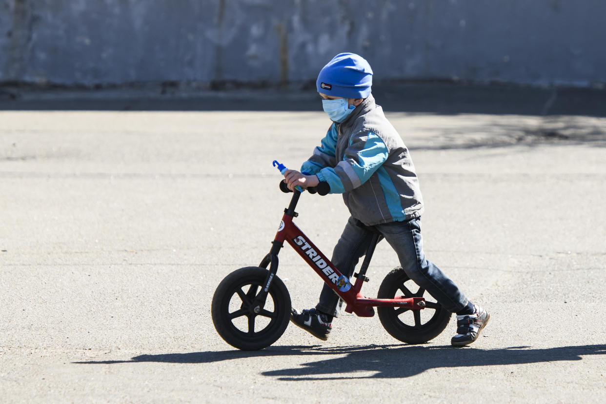 Boy in protective mask as a preventive measure against the coronavirus COVID-19 on a bicycle on street in Kyiv, Ukraine on April 06, 2020  (Photo by Maxym Marusenko/NurPhoto via Getty Images)