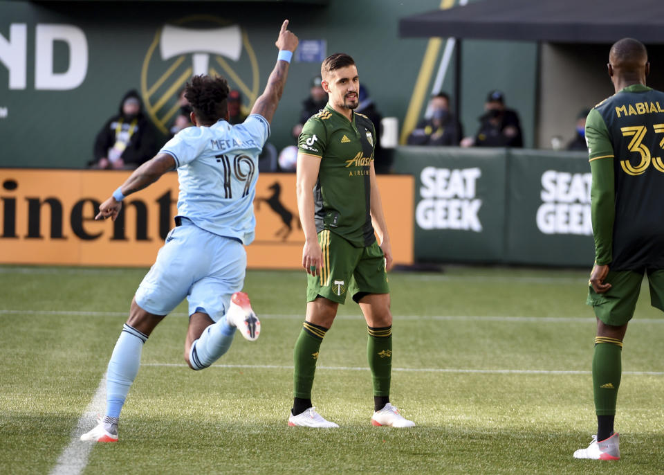 Minnesota United defender Romain Metanire, left, celebrates a goal by his teammate as Portland Timbers defender Jose van Rankin, center, and defender Larrys Mabiala, right, look on during the first half of an MLS soccer match in Portland, Ore., Sunday, Nov. 21, 2021. (AP Photo/Steve Dykes)