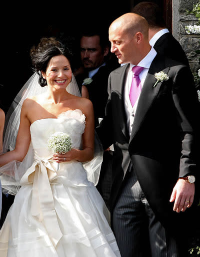 Andrea Corr: August 2009: Andrea Corr, one third of Irish band The Corrs married her stockbroker fiancé Brett Desmond in a full-skirted Vera Wang dress. The cream design was tied at the waist with a satin sash and featured a corsage adornment on the bust. Photo PA