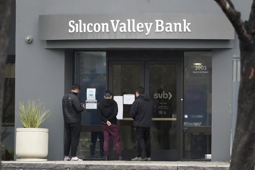 Хората гледат табели, поставени пред входа на Silicon Valley Bank в Санта Клара, Калифорния, петък, 10 март 2023 г. Федералната корпорация за гарантиране на депозитите конфискува активите на Silicon Valley Bank, отбелязвайки най-големия банков фалит след Washington Mutual по време разгара на финансовата криза от 2008 г. FDIC нареди затварянето на Silicon Valley Bank и незабавно зае позицията на всички депозити в банката в петък. (AP Photo/Джеф Чиу)