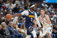 Denver Nuggets guard Reggie Jackson, left, passes the ball as Indiana Pacers guard T.J. McConnell, right, defends in the first half of an NBA basketball game Sunday, Jan. 14, 2024, in Denver. (AP Photo/David Zalubowski)