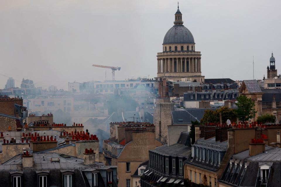 Smoke rising above the rooftops of Paris with the Pantheon in the background (REUTERS)