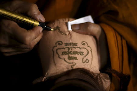 Buddhist monk Phra Winai Thidtapanyo, 64, anoints on a "child angel" doll during a blessing ritual at Wat Bua Khwan temple in Nonthaburi, Thailand, January 26, 2016. REUTERS/Athit Perawongmetha