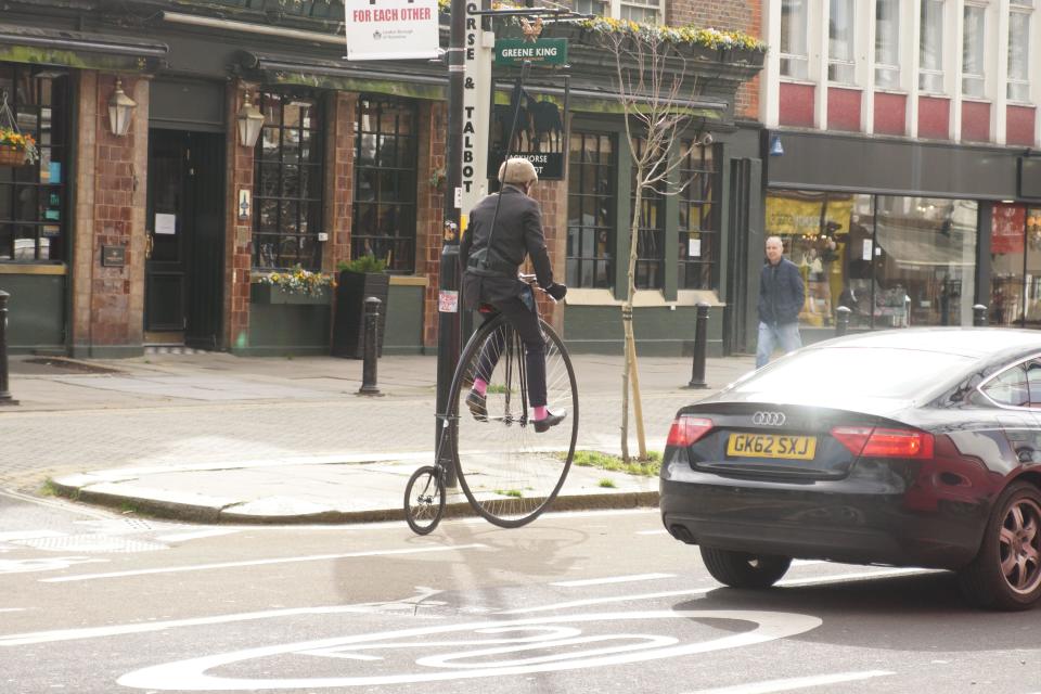 Jeremy Vine Remounts Penny-Farthing in Chiswick High Road. Television presenter Jeremy Vine dismounted his penny-farthing bicycle in Chiswick High Road to adjust a piece of personal equipment fastened around his waist. Passersby looked on with interest as he then remounted in the controversial cycle lane, C9. Credit: Peter Hogan/Alamy Live News
