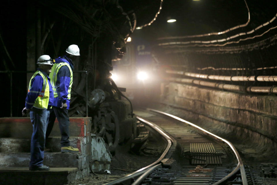 PATH superintendent of Power, Signals and Communications Division Radomir Bulayev, left, and Deputy Director Stephen Kingsberry watch as incoming train passes inside a tunnel, Tuesday, Nov. 27, 2012, in Hoboken, N.J. While parts of the trans-Hudson service have gradually returned to operation since Superstorm Sandy, the Hoboken station has been closed, leaving thousands of commuters to seek alternatives. (AP Photo/Julio Cortez)