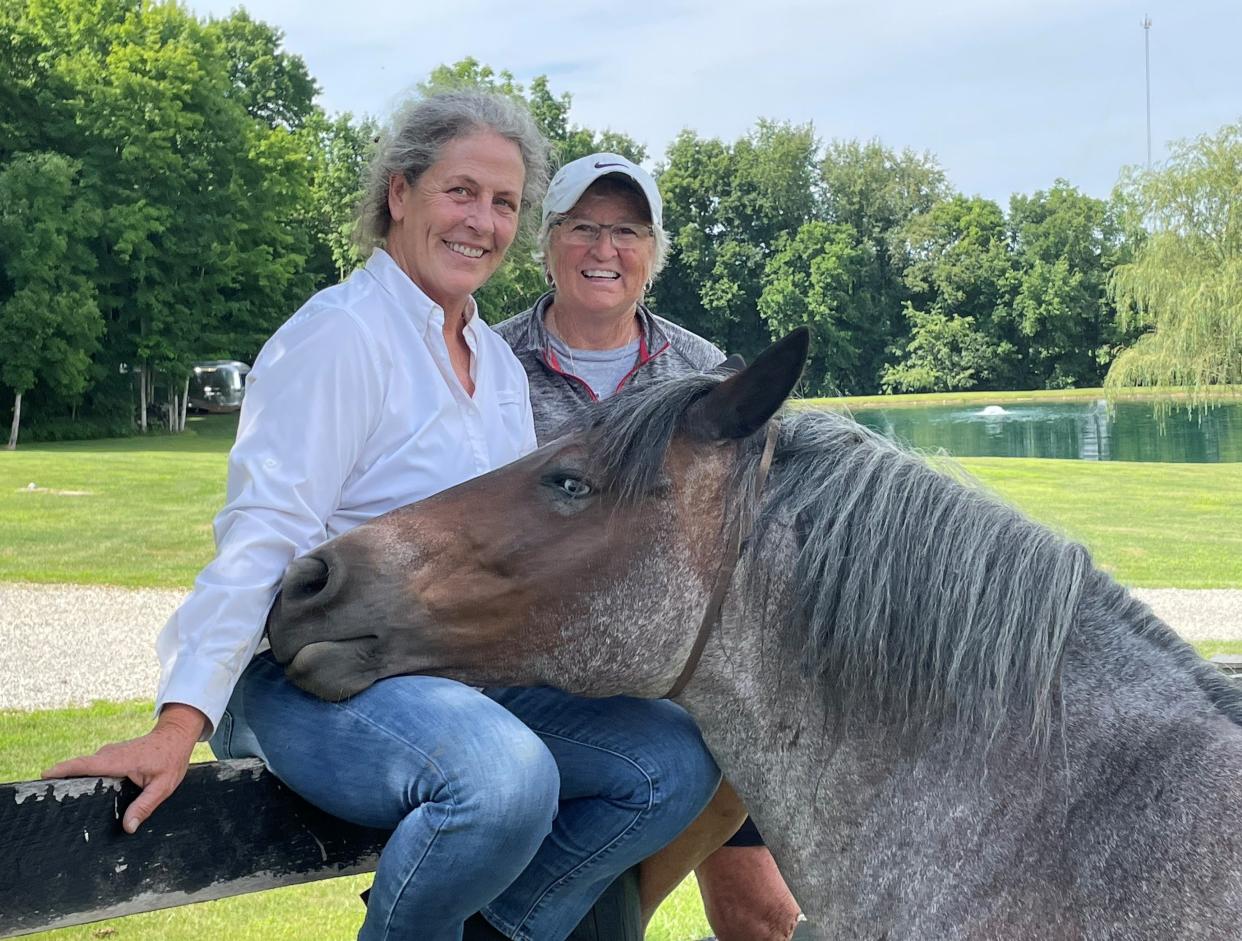 Leoti shares a tender moment with Kathryn King (left) and her friend Ruth Sunkle (right) last week on King's Valhalla Hill Farm near Alexandria. One of five Nokota healing medicine horses owned by King, Leoti starred in "Adeline," a recently-released movie made locally that features a heroic healing horse that saved 12 people during a tornado near a small Ohio town.