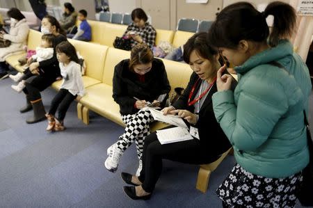 Dang Nguyen Thuc Vien (2nd R), a 32-year-old daughter of refugees from south Vietnam, helps a local Vietnamese resident in Japan as an interpreter at a hospital in Kanagawa prefecture, south of Tokyo, Japan, November 25, 2015. REUTERS/Yuya Shino