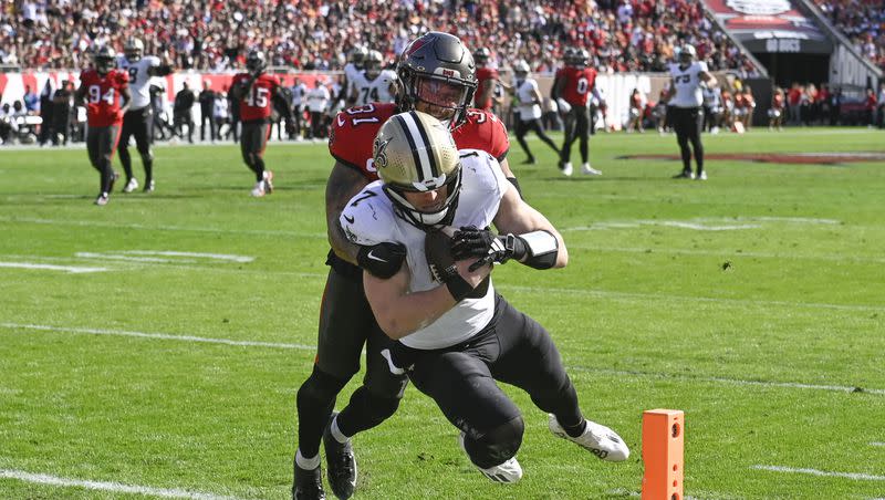 New Orleans Saints quarterback Taysom Hill (7) scores on a touchdown pass against Tampa Bay Buccaneers safety Antoine Winfield Jr. (31) in an NFL football game in Tampa, Fla., Sunday, Dec. 31, 2023.