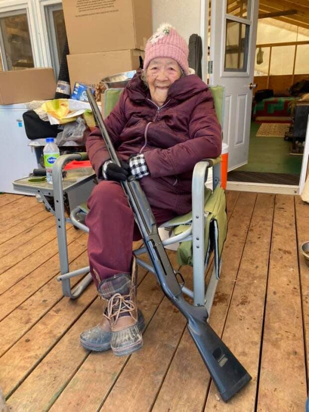 Mary Couchees Iserhoff sits with her 1985 semi-automatic 12-gauge rifle 'just in case,' says her son-in-law Kenny Blacksmith. (Submitted by Louise Iserhoff Blacksmith - image credit)