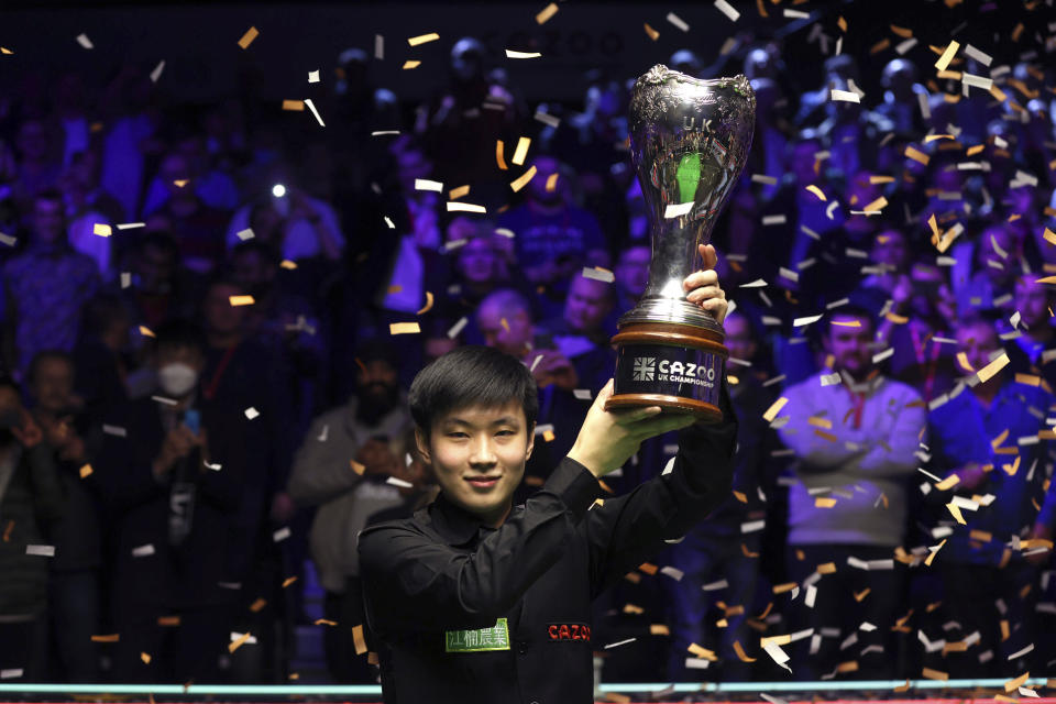 China's Zhao Xintong holds the trophy after winning the final of the Cazoo UK snooker Championship at the York Barbican, England, Sunday, Dec. 5, 2021. (Richard Sellers/PA via AP)