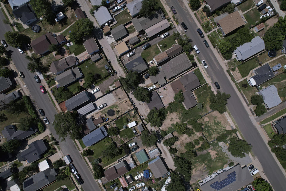 Trees dot the working class neighborhood of Globeville in Denver, July 24, 2023. Temperatures are hotter in America's low-income neighborhoods like the Denver suburb of Globeville, where many residents are low-income and people of color living in stretches of concrete that hold heat like a cast-iron skillet. Comparatively, in wealthy neighborhoods such as Country Club, mansions pocket a sea of vegetation which cools the area. (AP Photo/Brittany Peterson)