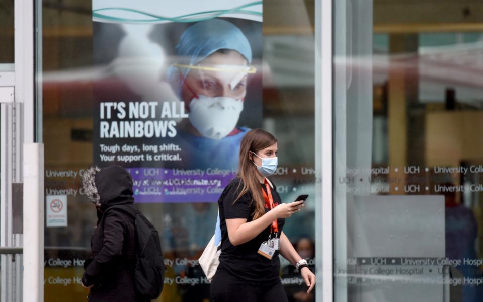 A woman walks past a sign at the University College Hospital in central London - Anadolu Agency