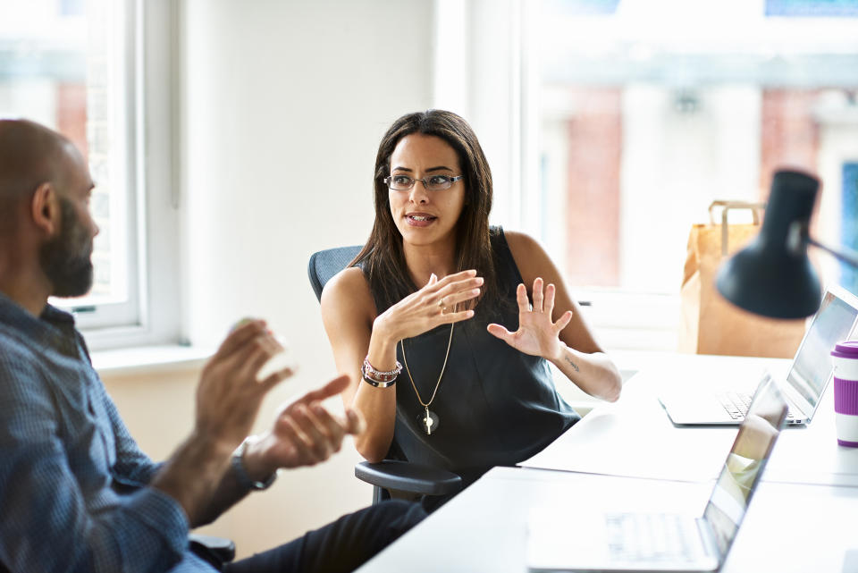 Woman and man talking in modern office.