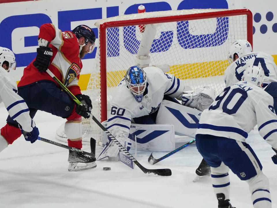 Toronto Maple Leafs goaltender Joseph Woll  clears the puck as Florida Panthers center Sam Bennett closes in during the first period.