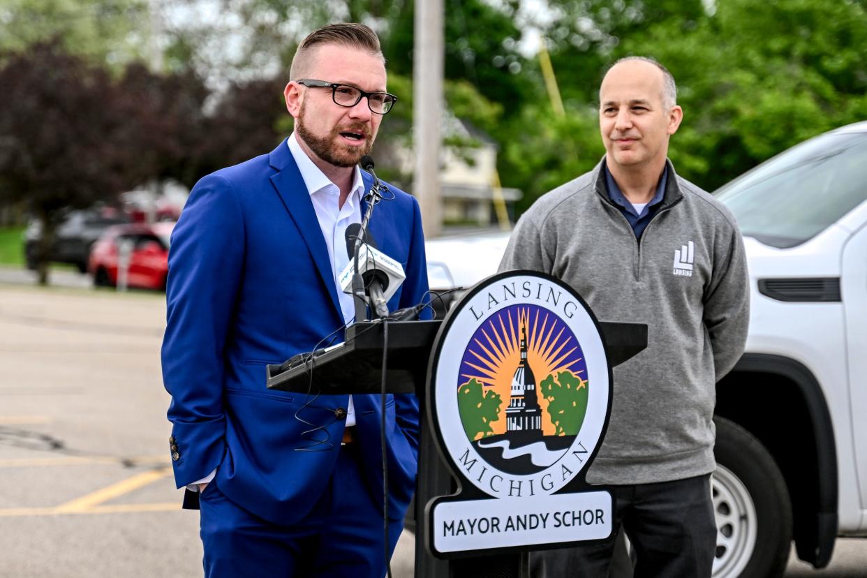 City council member Peter Spadafore speaks during a press conference at the proposed site of city hall at a parking lot on Grand Avenue across from CATA's downtown transportation center on Thursday, May 9, 2024, in Lansing. At right, Mayor Andy Schor looks on.
