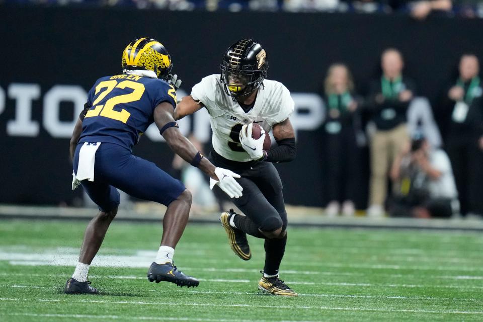 Purdue wide receiver Mershawn Rice, right, runs with the ball as Michigan defensive back Gemon Green (22) defends during the first half of the Big Ten championship NCAA college football game, Saturday, Dec. 3, 2022, in Indianapolis.