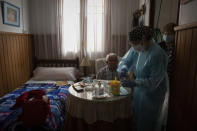 Nurse Pilar Rodríguez administers the COVID-19 vaccine to her patient Martín Gomila Serra, 82, at his home in the town of Sa Pobla on the Spanish Balearic Island of Mallorca, Spain, Friday, April 30, 2021. (AP Photo/Francisco Ubilla)