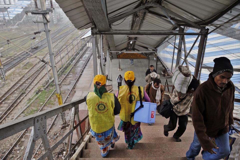 Indian medical volunteers arrive at a railway station to administer polio immunization drops to children in Allahabad, India, Monday, Jan. 13, 2014. India on Monday marked three years since its last polio case was reported, a major milestone in eradicating the crippling disease. (AP Photo/Rajesh Kumar Singh)