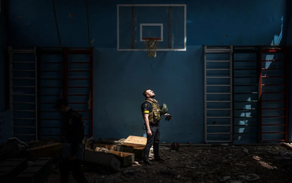 A Ukrainian policeman inside a school sport hall where Russian soldiers were believed to have been based in the village of Vilkhivka, near Kharkiv - GETTY IMAGES