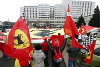 Ferrari fans from France, Italy and Germany display a giant Ferrari flag as they attend a silent 45th birthday tribute to seven-times former Formula One world champion Michael Schumacher in front of the CHU hospital emergency unit in Grenoble, French Alps, where Michael Schumacher is hospitalized January 3, 2014. His agent said on Wednesday that Michael Schumacher was in a stable condition and it was too early to talk about his further prospects. No further update was given on Thursday, the day before his 45th birthday. Schumacher is battling for his life after slamming his head against a rock while skiing off-piste in the French resort of Meribel on Sunday. REUTERS/Charles Platiau