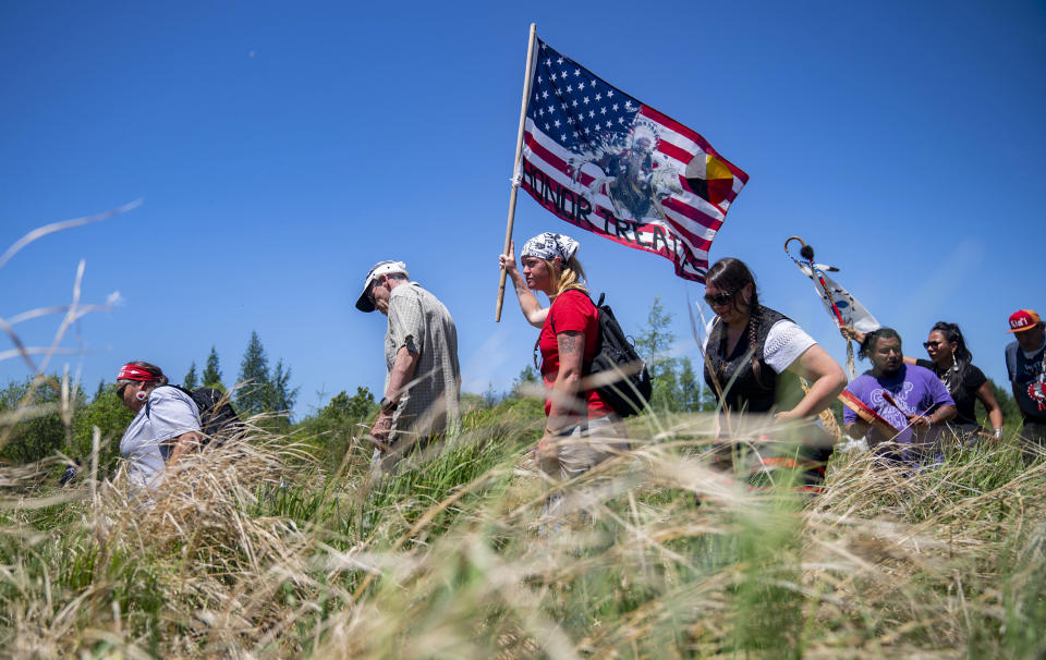 Indigenous leaders and "water protectors" march through swamp land to the boardwalk leading to an Enbridge pipeline construction site, on Monday, June 7, 2021, in Clearwater County, Minn. More than 2,000 Indigenous leaders and "water protectors" gathered in Clearwater County from around the country to protest the construction of Enbridge Line 3. The day started with a prayer circle and moved on to a march to the Mississippi headwaters where the oil pipeline is proposed to be built. (Alex Kormann/Star Tribune via AP)