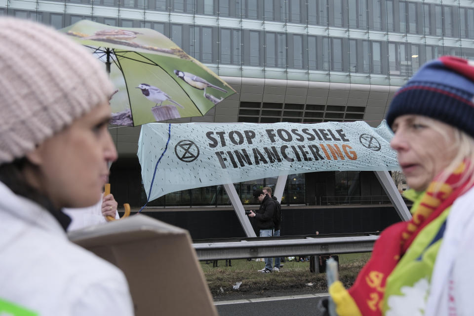 Climate activists block the main highway around Amsterdam near the former headquarters of a ING bank to protest its financing of fossil fuels, Saturday, Dec. 30, 2023. Protestors walked onto the road at midday, snarling traffic around the Dutch capital in the latest road blockade organized by the Dutch branch of Extinction Rebellion. (AP Photo/Patrick Post)