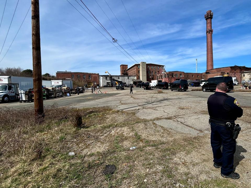 A Taunton police officer working a paid detail on Monday, April 8, 2024, keeps an eye on Whittenton Mills during filming of scenes for the AMC television show "The Walking Dead: Dead City."