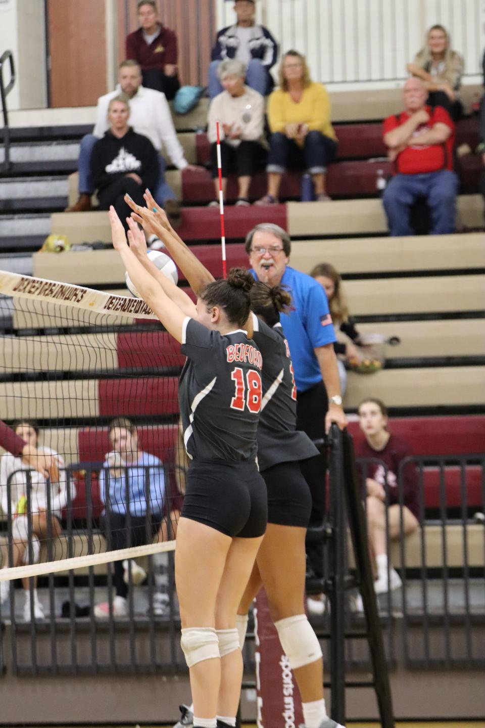 Bedford's Kadie Morse and Jaelyn Hall reach up for a double block against Dexter Thursday, September 28, 2023.