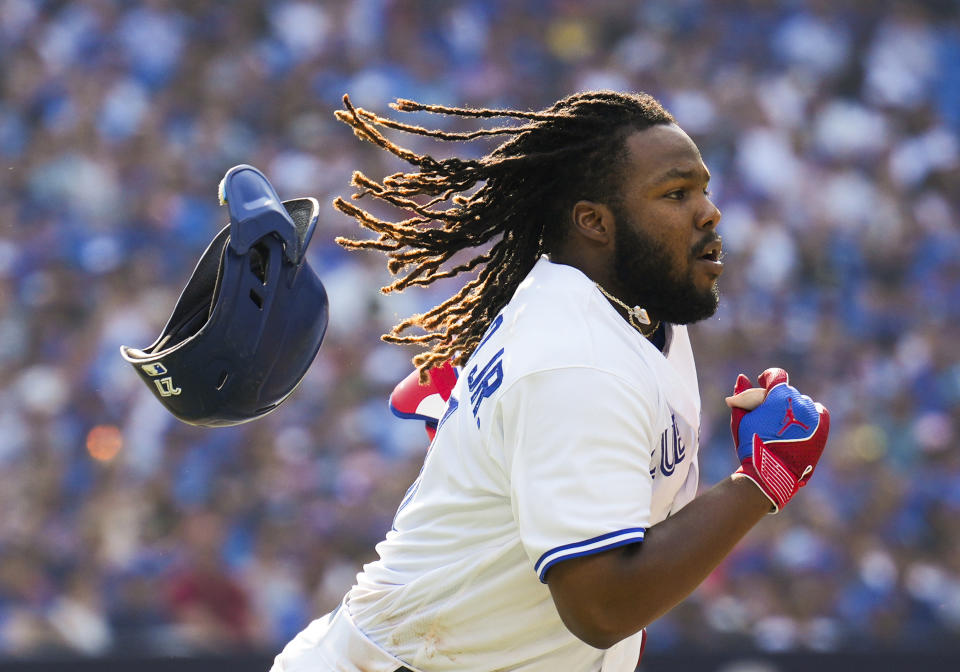 Toronto Blue Jays' Vladimir Guerrero Jr.'s (27) helmet flies off his head as he runs to first base on his RBI single against the Baltimore Orioles during the sixth inning of a baseball game in Toronto, Thursday Aug. 3, 2023. (Mark Blinch/The Canadian Press via AP)
