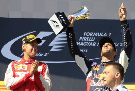 Red Bull Formula One driver Daniel Ricciardo of Australia (R) celebrates his third place as Ferrari Formula One driver Sebastian Vettel of Germany (L) applauds after the Hungarian F1 Grand Prix at the Hungaroring circuit, near Budapest, Hungary July 26, 2015. REUTERS/Bernadett Szabo