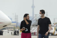 Michael Kovrig, right, talks with his wife Vina Nadjibulla, center left, after his arrival at Pearson International Airport in Toronto, Saturday, Sept. 25, 2021. China, the U.S. and Canada completed a high-stakes prisoner swap Saturday with joyous homecomings for Kovrig and Michael Spavor, two Canadians held by China and for an executive of Chinese global communications giant Huawei Technologies charged with fraud. (Frank Gunn /The Canadian Press via AP)