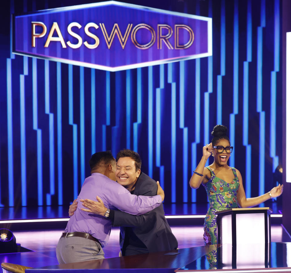 This image released by NBC shows Jimmy Fallon, center, embracing a contestant as host Keke Palmer, looks on, during the game show "Password." (Jordin Althaus/NBC via AP)